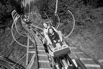 Zwei Personen im Schlitten der Sommerrodelbahn Arena Coaster