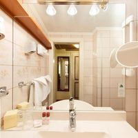 Blick auf Spiegel, Waschbecken und Duschkabine im Badezimmer